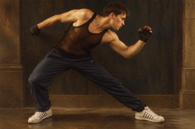 a man in black shirt and blue pants doing a kick