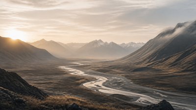 a vast valley with a river winding toward distant mountains at sunrise, no people, no text