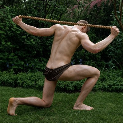 a man in a bathing suit is holding a rope