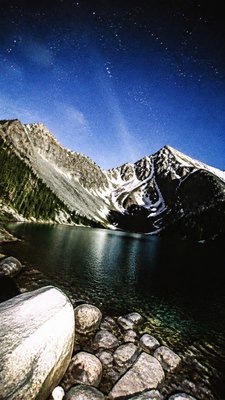 a tranquil mountain lake beneath a starry night sky, no people, no text