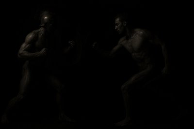 a couple of men standing next to each other in the dark