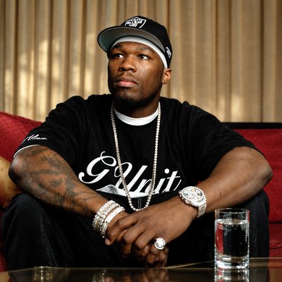 a man sitting on top of a red couch next to a glass of water