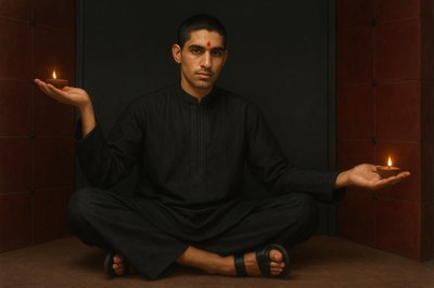 a man sitting in a lotus position with a lit candle in his hand