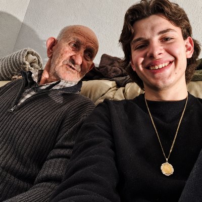 a man sitting next to an older man on a couch