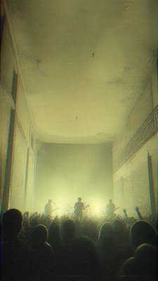 a live music scene with a glowing stage and silhouetted crowd, energetic vertical composition with open space at the top, no text