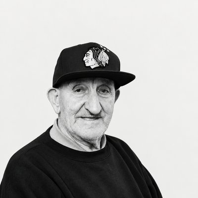 a black and white photo of a man wearing a hat