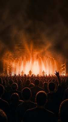 a live music scene with a glowing stage and silhouetted crowd, energetic vertical composition with open space at the top, no text