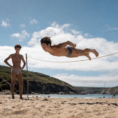 a young man is playing volleyball on the beach