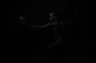 a man holding a ball in the dark