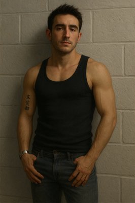 a man standing in front of a brick wall