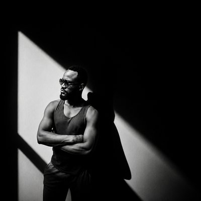 a man standing in a dark room with his arms crossed