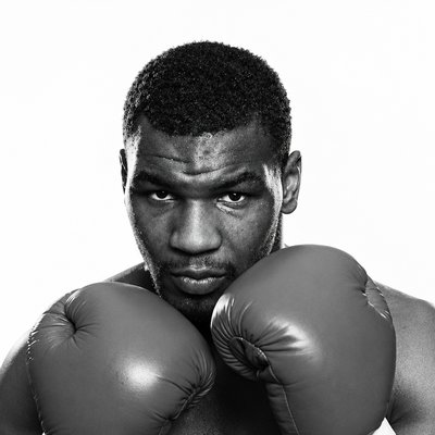 a black and white photo of a man wearing boxing gloves