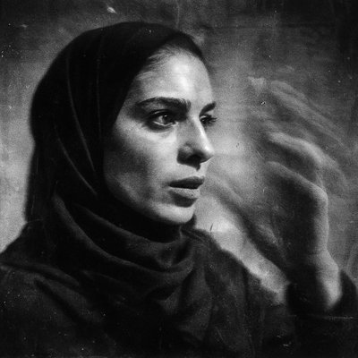a black and white photo of a woman wearing a headscarf