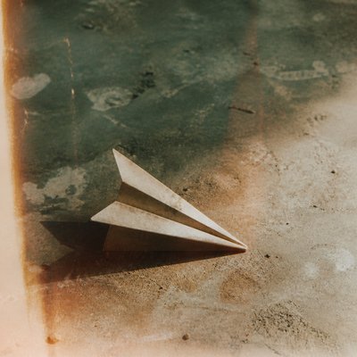 a paper plane, clean minimal composition on a plain background, no text