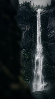 towering waterfall cascading down a cliff