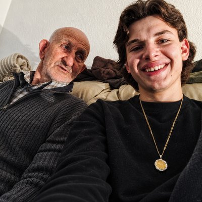 a man sitting next to an older man on a couch
