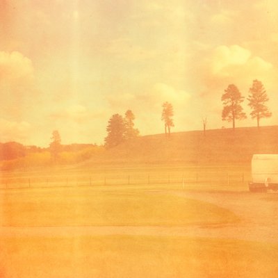 a white truck driving down a road next to a lush green field