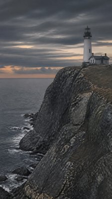 a lone lighthouse on a cliff at dusk under a dramatic sky, no text or lettering