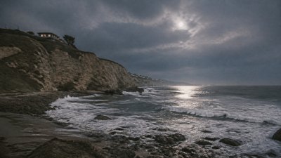 a moonlit coastline with cliffs and crashing surf, no people