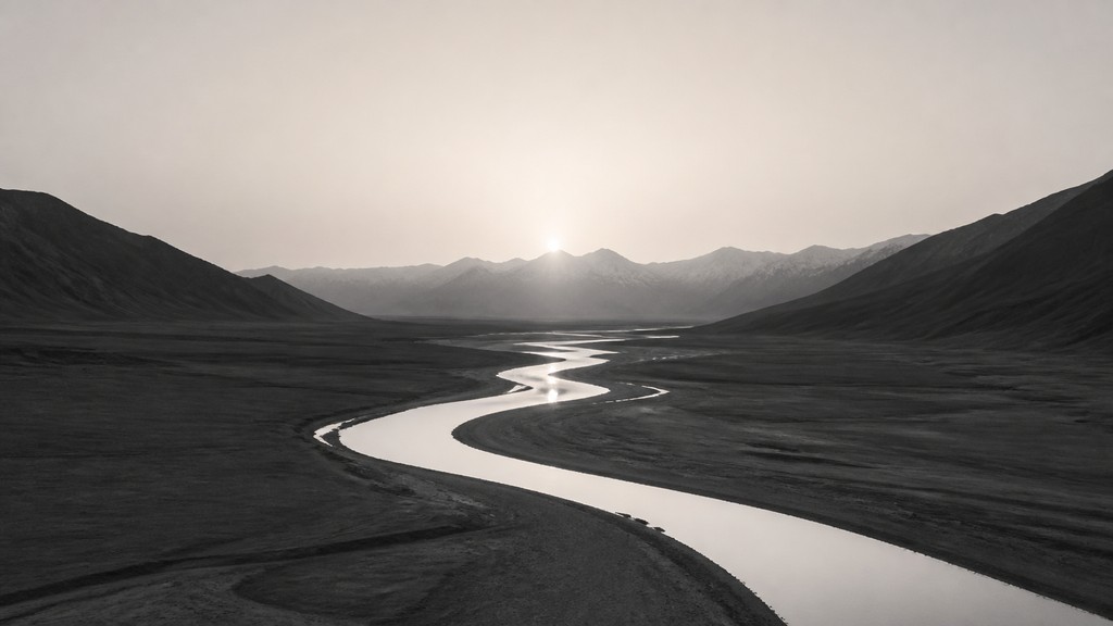a vast valley with a river winding toward distant mountains at sunrise, no people, no text