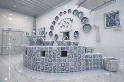 a blue and white kitchen with a lot of plates on the wall