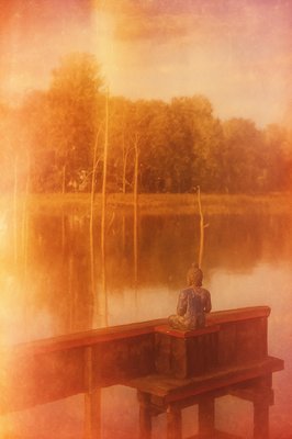 a person sitting on a bench next to a body of water