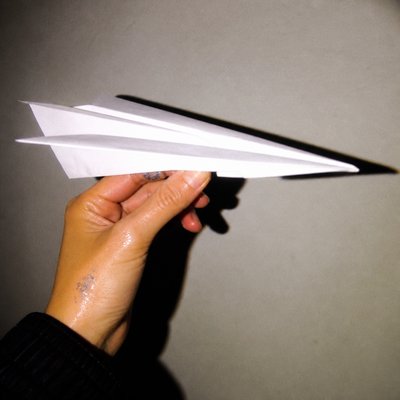 a paper plane, clean minimal composition on a plain background, no text