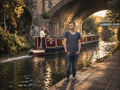 a man standing next to a boat on a river