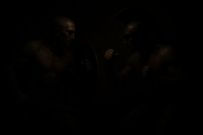 a couple of men standing next to each other in the dark