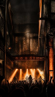 a live music scene with a glowing stage and silhouetted crowd, energetic vertical composition with open space at the top, no text
