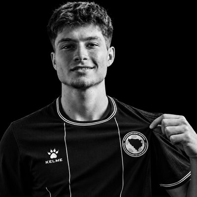 a black and white photo of a man holding a soccer jersey