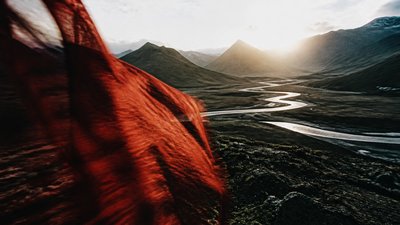 a vast valley with a river winding toward distant mountains at sunrise, no people, no text