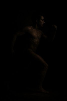 a man standing in the dark with no shirt on
