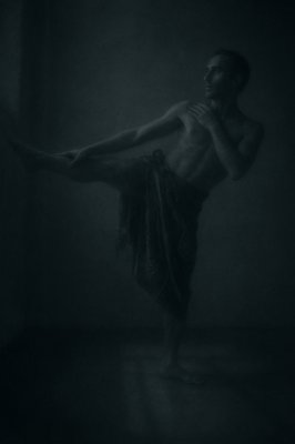 a man with a towel on his head is dancing in the dark