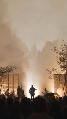 a live music scene with a glowing stage and silhouetted crowd, energetic vertical composition with open space at the top, no text