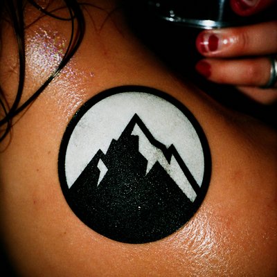 an emblem of a mountain peak inside a circle, simple bold shapes on a plain background, no text or lettering