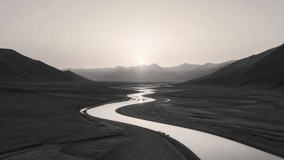 a vast valley with a river winding toward distant mountains at sunrise, no people, no text