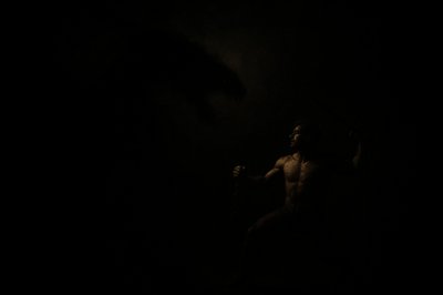 a man standing in the dark holding a stick