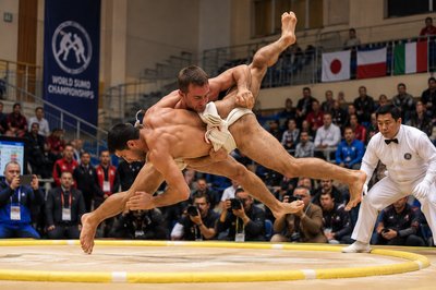 two sumo wrestlers in the middle of a wrestling match