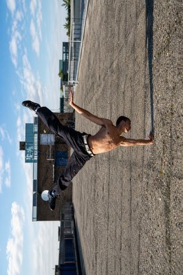 a man with no shirt is playing frisbee