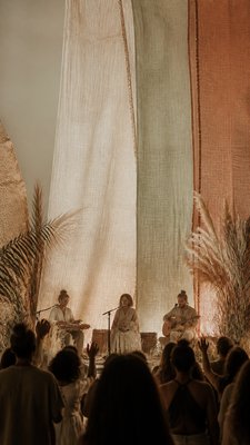 a live music scene with a glowing stage and silhouetted crowd, energetic vertical composition with open space at the top, no text