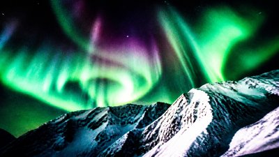 a flowing aurora over snowy peaks, wide sweeping composition, no people, no text
