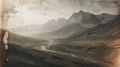 a vast valley with a river winding toward distant mountains at sunrise, no people, no text