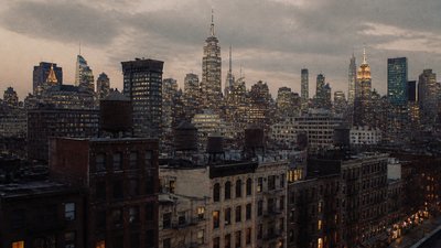 a city skyline panorama at dusk with glowing windows, no people