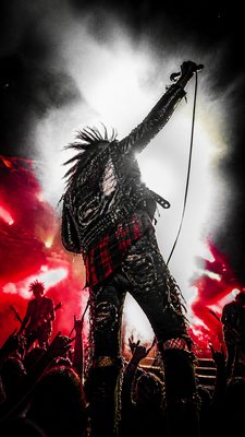 a live music scene with a glowing stage and silhouetted crowd, energetic vertical composition with open space at the top, no text