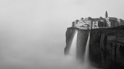 a cliffside city with waterfalls cascading into a misty canyon, wide establishing shot, no people, no text