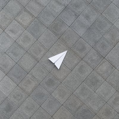a paper plane, clean minimal composition on a plain background, no text