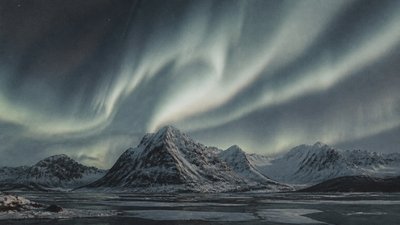 a flowing aurora over snowy peaks, wide sweeping composition, no people, no text
