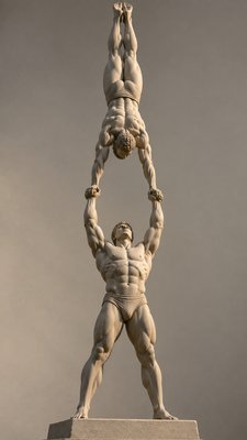 olympic male acrobat holding the hands of another acrobat balancing himself upside down
