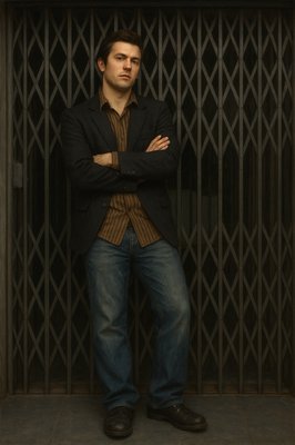 a man standing in front of a gate with his arms crossed